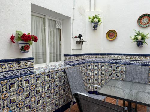 een patio met een tafel en een raam met bloemen bij Apartamento Buen Pastor con parking gratuito in Córdoba