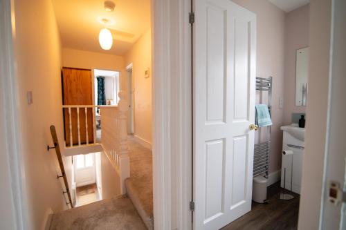 a hallway with a white door leading to a bathroom at Boursault Rose *4 Bed *WiFi *Canterbury in Canterbury