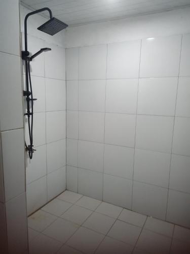 a bathroom with a shower with white tiles at Renata Cottages in Ohoililir