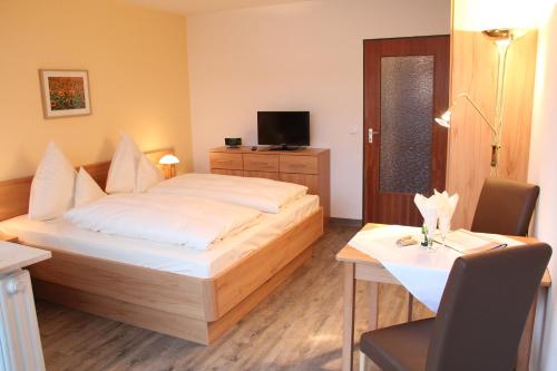 a hotel room with a bed and a table and a television at Chalet Swiss - Appartementhotel in Bad F&uuml;ssing