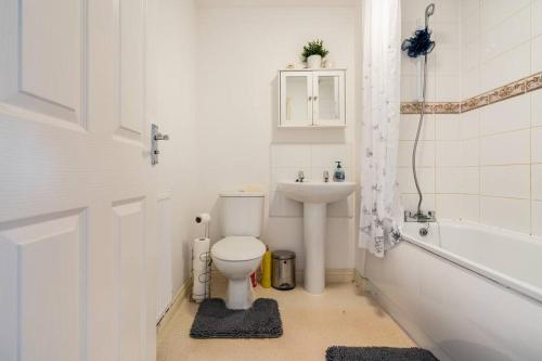 een badkamer met een toilet, een wastafel en een bad bij Grenadier House in Coventry
