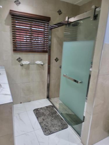 a bathroom with a shower with a glass door at The Royal at Meadowbrook. in Kingston