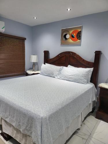 a bedroom with a large bed with a white bedspread at The Royal at Meadowbrook. in Kingston