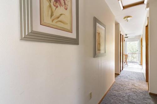 a hallway with white walls and paintings on the wall at Bass Creek's Apt A in Janesville