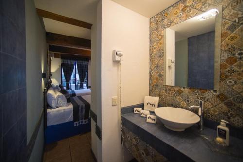 y baño con lavabo y espejo. en Casa de los Frailes, en Oaxaca City