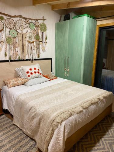 a bedroom with a large bed and green cabinets at Apartamento El Raulí in Futrono