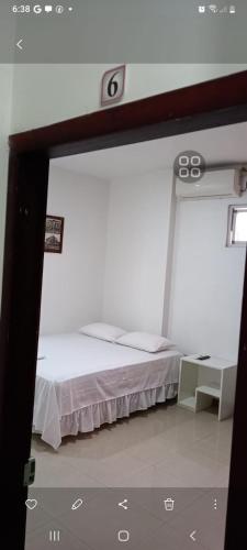 Cama en habitación blanca con: en HOTEL JW MENDOZA VIVAS, en Calceta