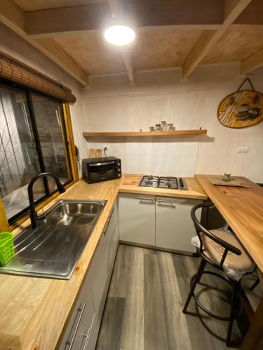 a small kitchen with a sink and a stove at Apartamento El Raulí in Futrono