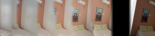 a room with pink walls and pillows on a couch at Portal Dos Leões in Piranhas