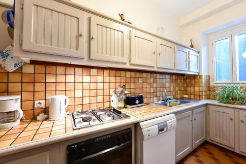 a kitchen with white cabinets and a stove top oven at Etchevers-enia in Suhescun