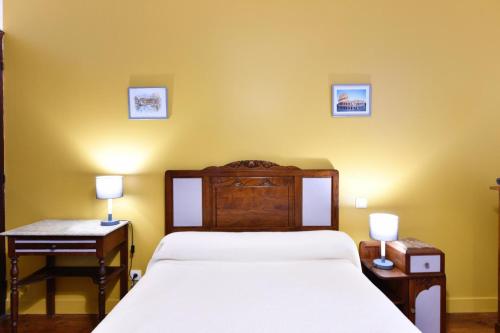 a bedroom with a bed and two tables and two lamps at Etchevers-enia in Suhescun