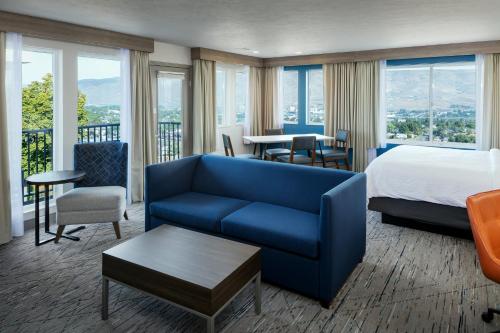 una camera d'albergo con un letto e un divano blu di Holiday Inn Express Lewiston, an IHG Hotel a Lewiston