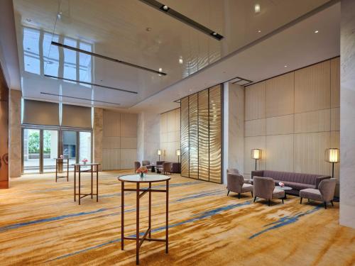 a lobby of a hotel with tables and chairs at InterContinental Chongqing Raffles City by IHG in Chongqing