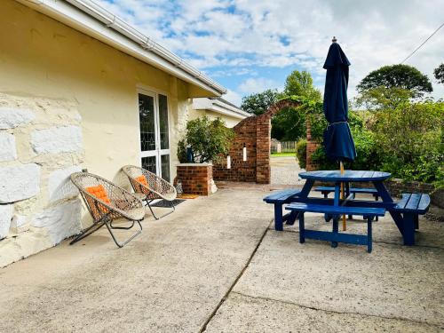 einem blauen Picknicktisch mit Sonnenschirm und Stühlen in der Unterkunft The annex on our farm in Colwyn Bay