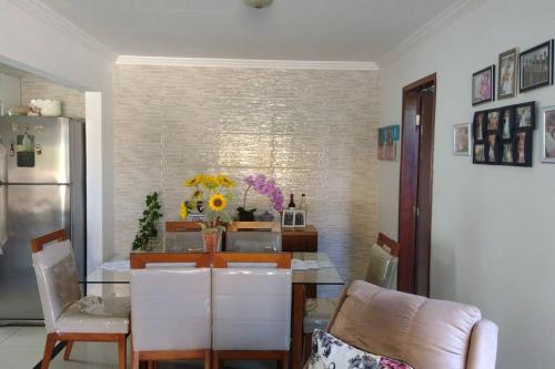 a dining room with a table and a refrigerator at Cozy Home Arembepe Beach in Camaçari