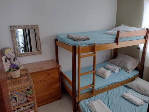 a bedroom with two bunk beds and a mirror at Cozy Home Arembepe Beach in Camaçari