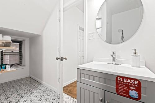 uma casa de banho branca com um lavatório e um espelho em Tranquil Haven Retreat em Detroit