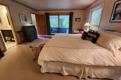 een slaapkamer met een groot bed en een woonkamer bij Birchwood Lakeview in Harbor Springs