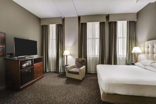 a hotel room with a bed and a flat screen tv at Drury Plaza Hotel New Orleans in New Orleans