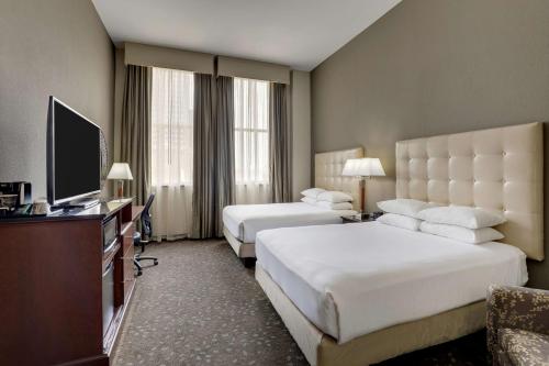 a hotel room with two beds and a flat screen tv at Drury Plaza Hotel New Orleans in New Orleans