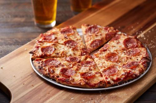 a pepperoni pizza on a plate on a table at Drury Plaza Hotel New Orleans in New Orleans