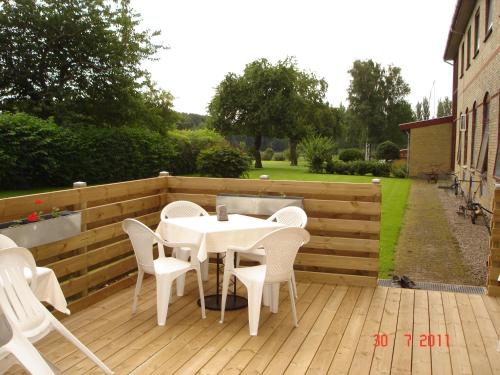 a patio with a table and chairs on a wooden deck at Nygammelsø Bed & Breakfast in Stege