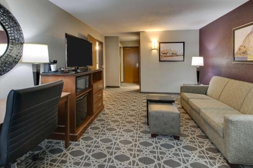 a living room with a couch and a flat screen tv at Drury Inn & Suites Poplar Bluff in Poplar Bluff