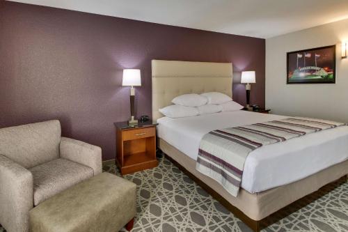 een hotelkamer met een bed en een stoel bij Drury Inn & Suites Poplar Bluff in Poplar Bluff