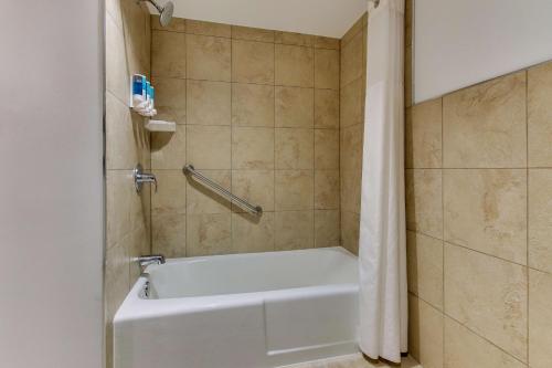 a bathroom with a bath tub with a shower curtain at Drury Inn & Suites Poplar Bluff in Poplar Bluff