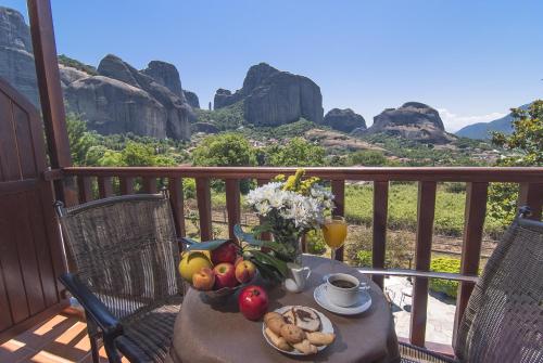 a table with fruit and vegetables on a balcony with rocks at Hotel Doupiani House in Kalabaka
