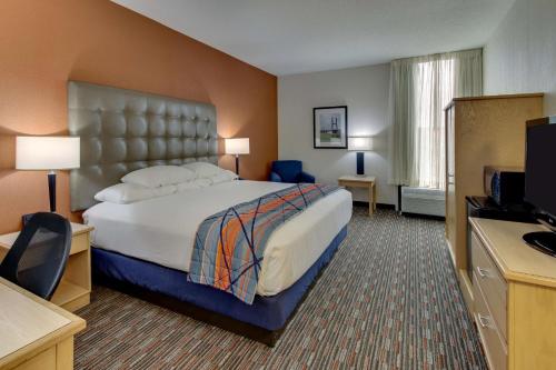 Habitación de hotel con cama y TV en Pear Tree Inn Cape Girardeau West en Cape Girardeau