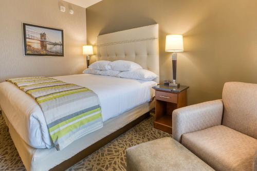 um quarto de hotel com uma cama e uma cadeira em Drury Inn & Suites Cincinnati Northeast Mason em Mason