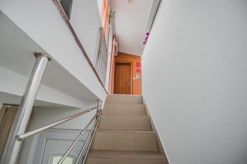 a stairway in a building with a door and stairs at Apartments Villa Monique in Rogoznica