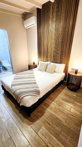 a bedroom with a large bed with a wooden wall at Luxury Home In Aguacatala in Medellín