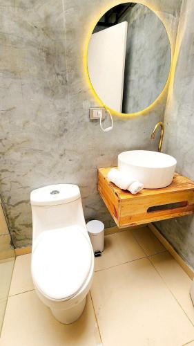 a bathroom with a toilet and a sink and a mirror at Luxury Home In Aguacatala in Medellín
