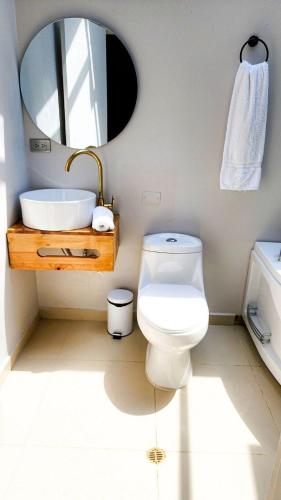 a bathroom with a toilet and a sink and a mirror at Luxury Home In Aguacatala in Medellín