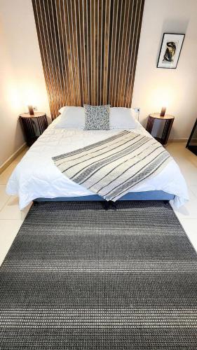 a bedroom with a large bed with a black carpet at Luxury Home In Aguacatala in Medellín