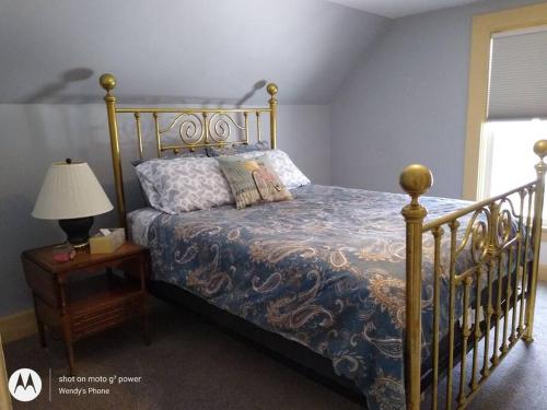 a bedroom with a bed and a table with a lamp at Bass Creek's Cozy Outback Country Retreat in Janesville