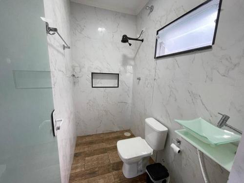 een witte badkamer met een wastafel en een toilet bij Chácara pôr do sol in Socorro