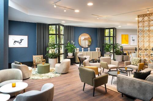 a waiting room with couches and tables at voco Vienna Prater, an IHG Hotel in Vienna