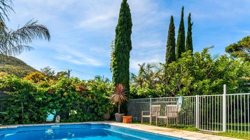 a swimming pool with two chairs and trees at Shoal Bay Riggers - 7 Rigney St, Shoal Bay in Shoal Bay