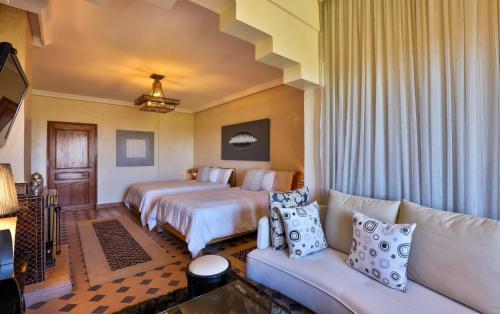 a hotel room with two beds and a couch at Palais Amador in Oulad Mazoug