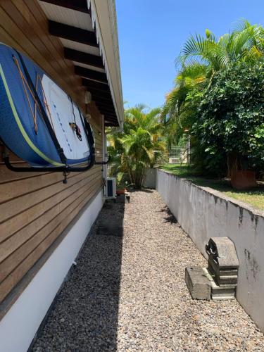 a surfboard sitting on the side of a house at Les Frangipaniers de la Pelée in Saint-Pierre