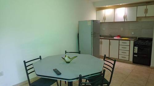 eine Küche mit einem Tisch und Stühlen sowie einem Kühlschrank in der Unterkunft DEPARTAMENTO BOLIVAR PLANTA BAJA in San Carlos de Bolívar