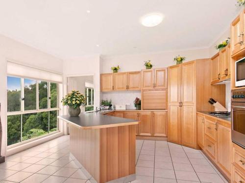 a large kitchen with wooden cabinets and a large window at *Casa Al Lago* in Montville