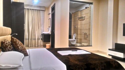 a room with a desk and a bathroom with a toilet at Kanchan Recreation in Maheshwar