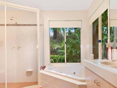 ein Bad mit einer Badewanne, einem Waschbecken und einem Fenster in der Unterkunft *Casa Al Lago* in Montville
