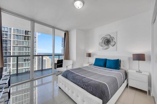 a white bedroom with a bed and a large window at *W ICON BRICKELL- LUXURY 2BR HIGHRISE CORNER CONDO** in Miami
