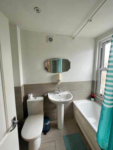a bathroom with a toilet and a sink and a tub at Fulham suites in London