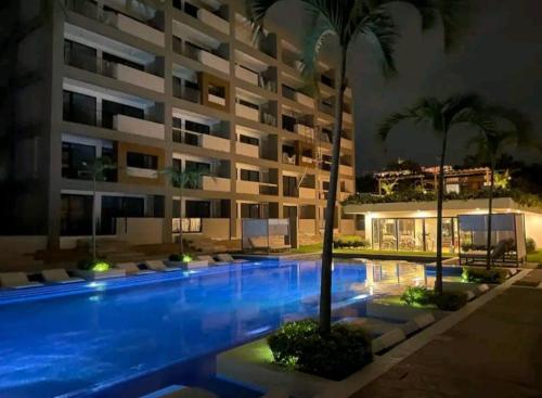 a swimming pool in front of a building at night at Departamento nuevo con vista a la Piscina in Nuevo Vallarta 